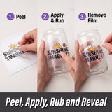 Three-panel instruction graphic showing how to reveal a 'SUNSHINE MARKET' design on a clear glass can. Step 1 shows peeling a white film from a printed design, step 2 shows applying and rubbing the film onto the glass, and step 3 shows the final revealed design.