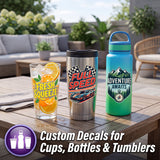 Three insulated drink containers on a wooden patio table: a clear glass with a yellow 'Fresh Squeeze' citrus decal, a stainless steel tumbler with a red 'Full Speed' race decal, and a blue-to-green water bottle with a teal 'Adventure Awaits' mountain decal. Text at the bottom reads 'Custom Decals for Cups, Bottles & Tumblers'.