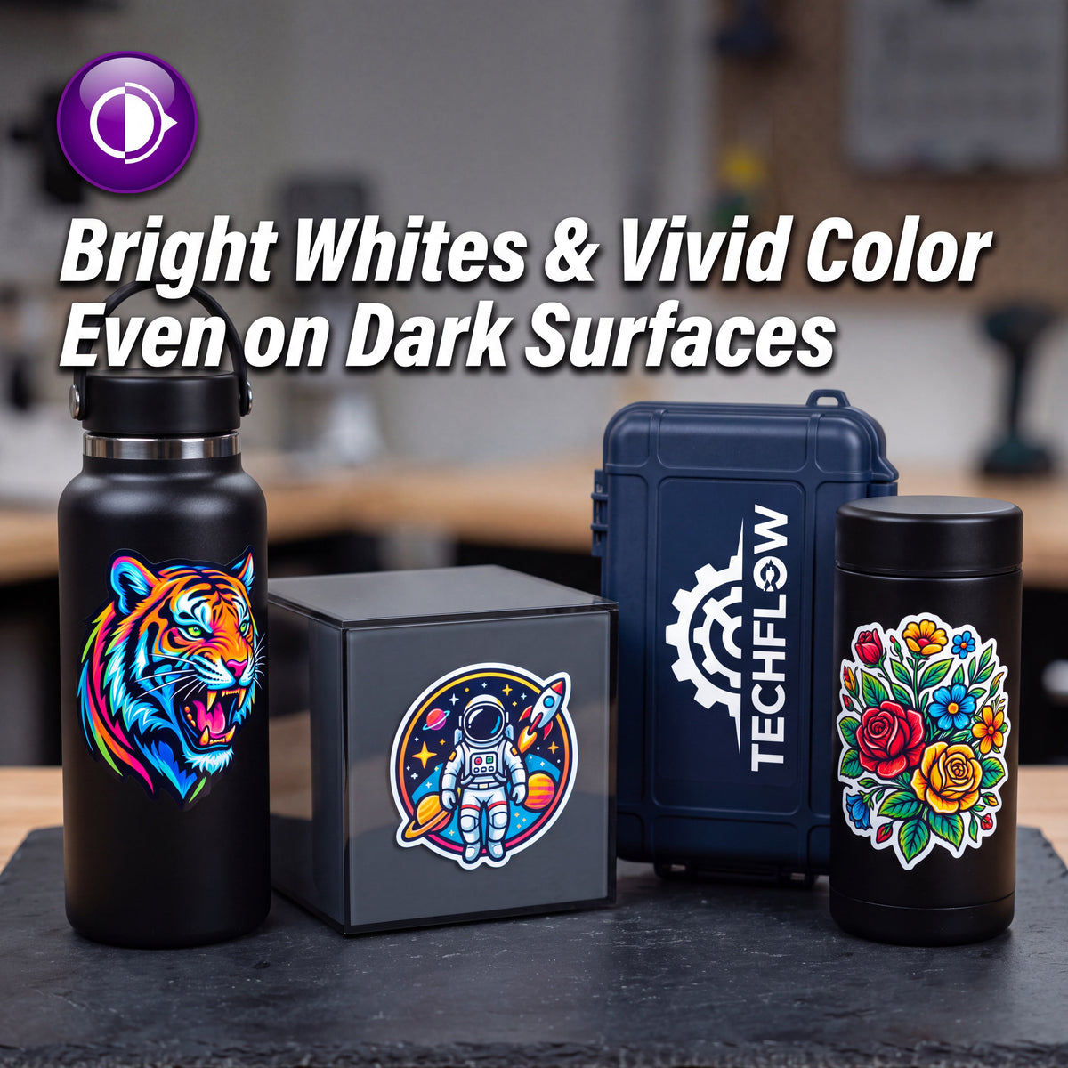 Four insulated containers displayed together on a dark tabletop: a matte black bottle with a colorful tiger graphic, a dark gray box with a circular astronaut graphic, a navy hard case with TECHFLOW branding, and a black canister with a multicolor floral design. Large promotional text at the top reads, 'Bright Whites & Vivid Color Even on Dark Surfaces.